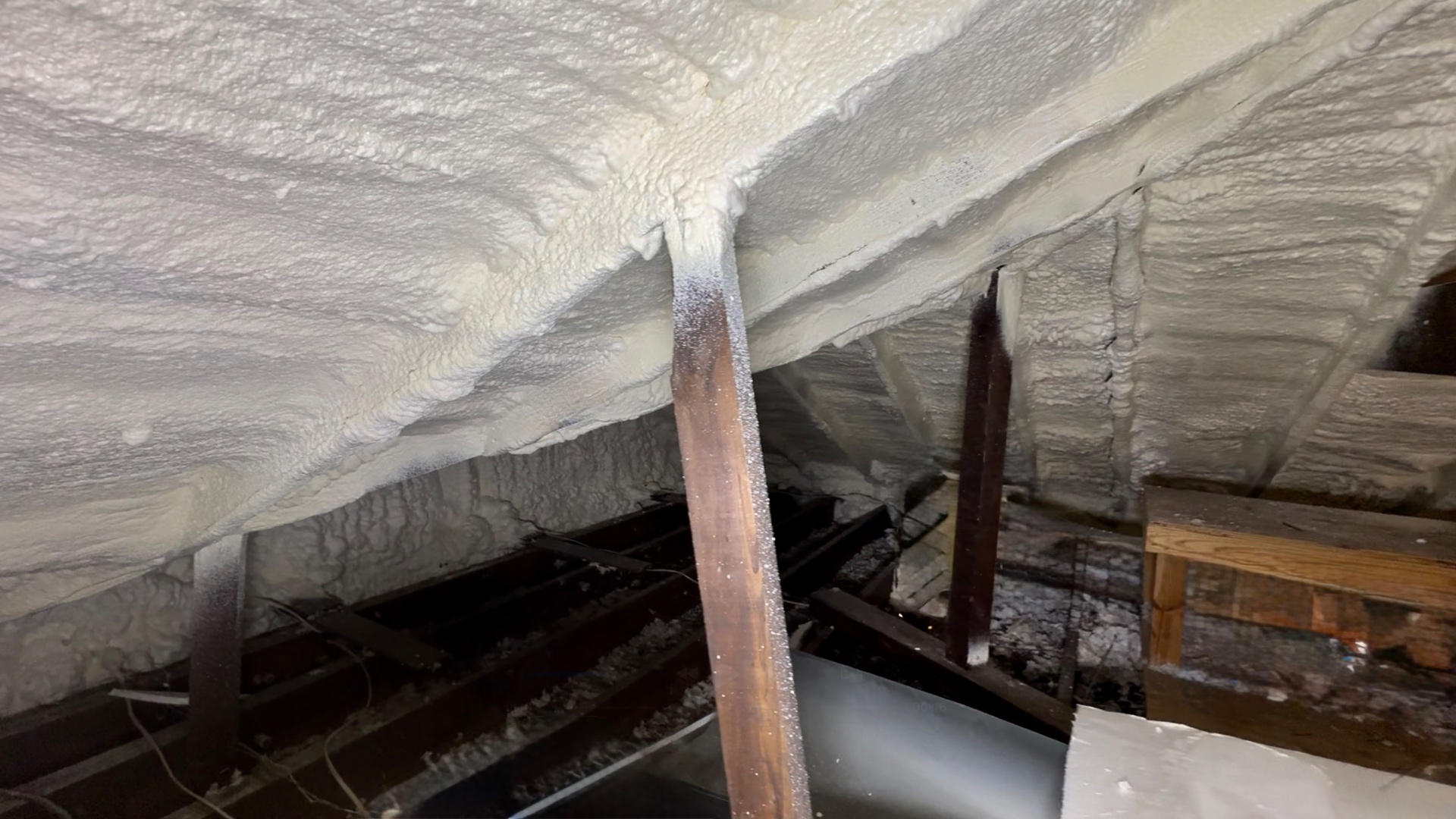 Attic roof deck fully foamed with a light flash coat applied along the sides of the exposed rafters, per client preference.